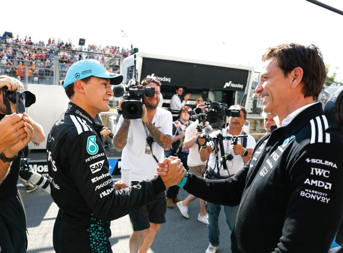two men shaking hands in front of a crowd