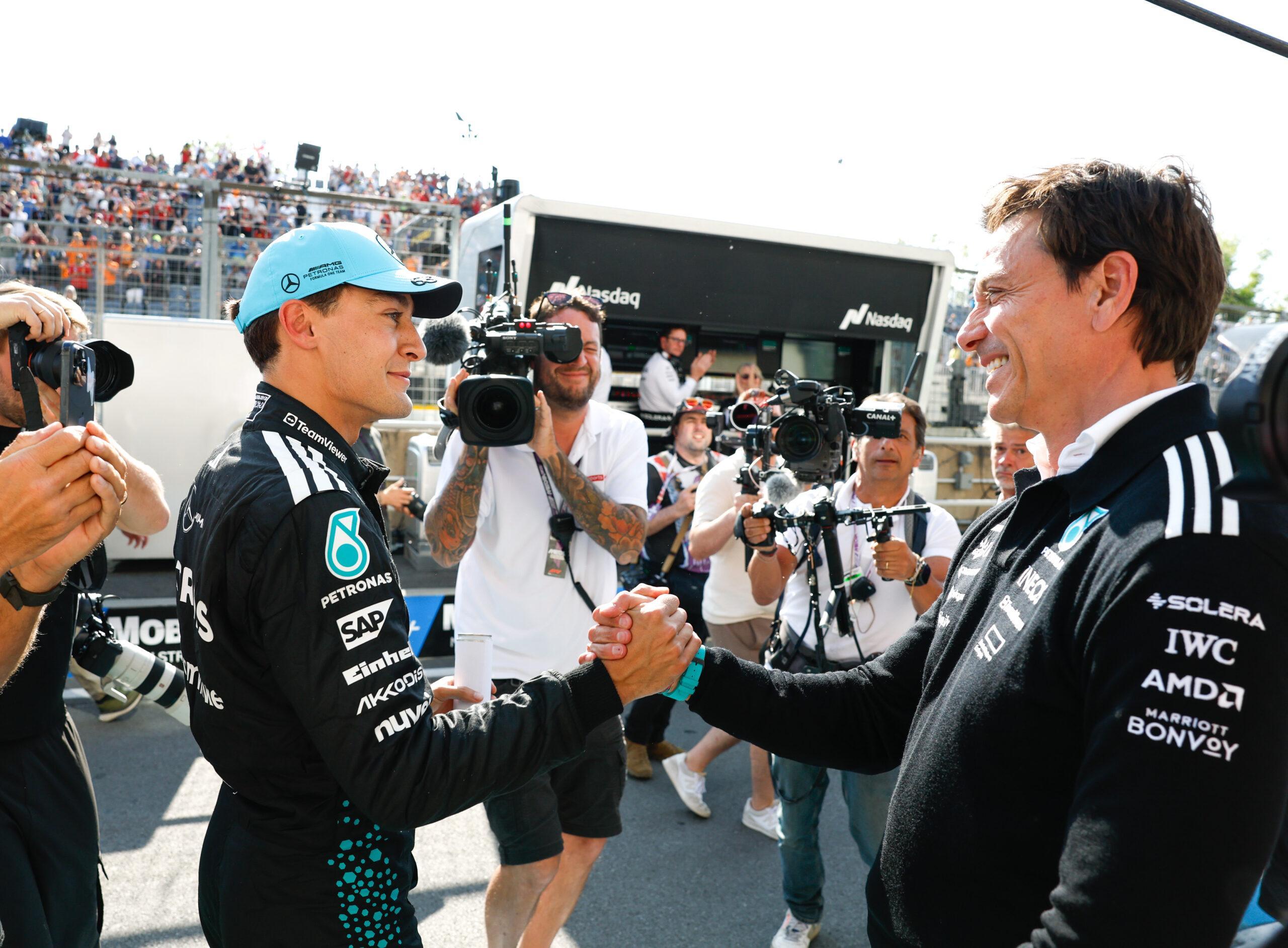 two men shaking hands in front of a crowd
